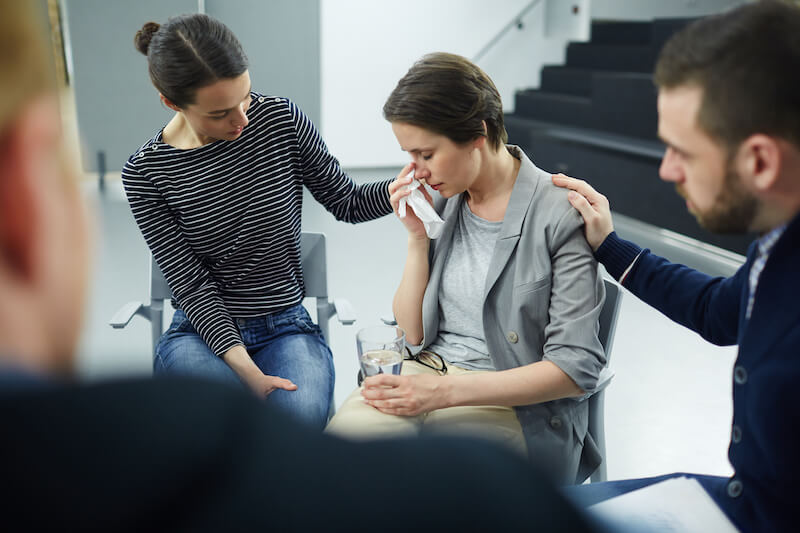 God wipe away all tears showing a woman crying and friends comforting her