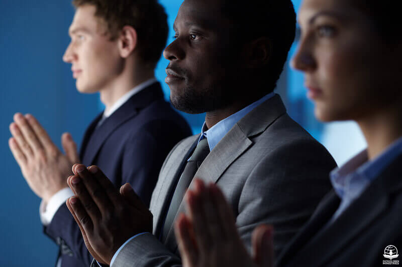 Spirit helps our weaknesses in prayer showing a group of business men praying
