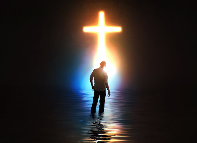 abide under the shadow of the Almighty showing a man before a cross
