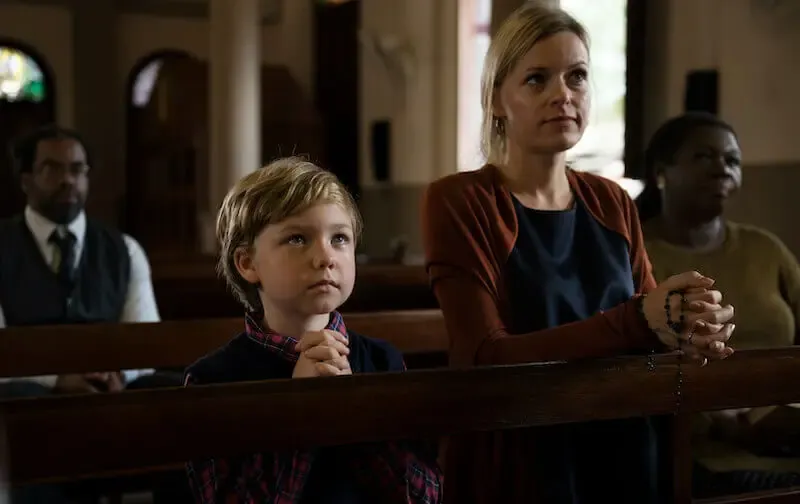 christian religion showing a woman and child in church