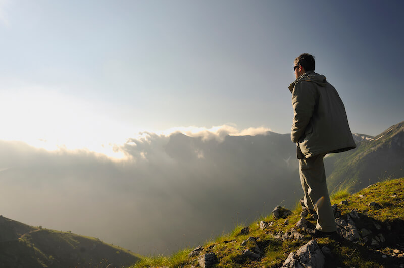 compassing the mountain showing a man looking at a mountain