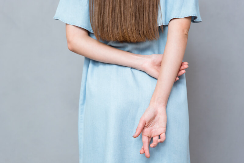deception showing a woman with hands crossed behind her