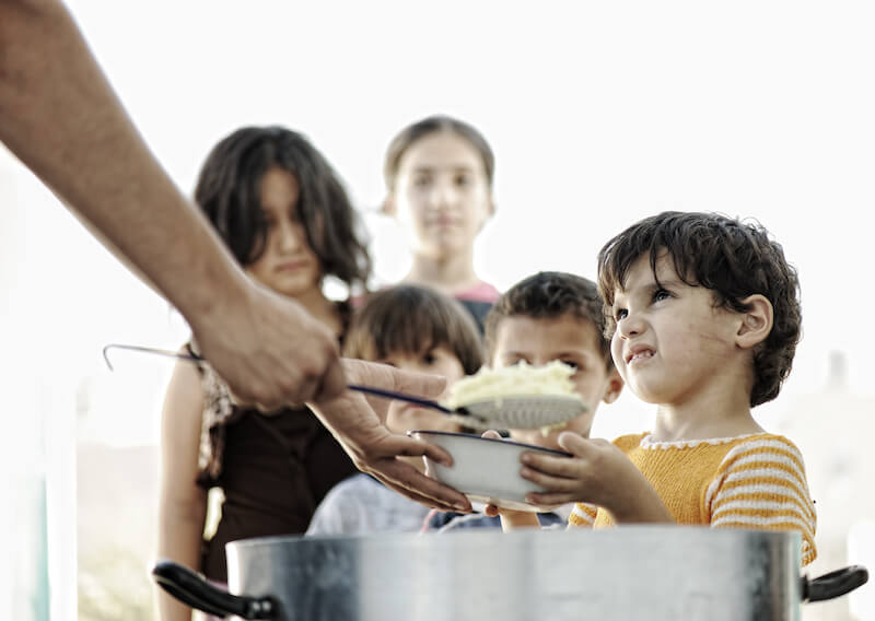 distributing to the necessity of saints showing hungry children in a camp