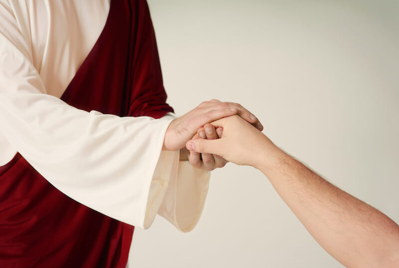 faithfulness showing a man holding Jesus hands