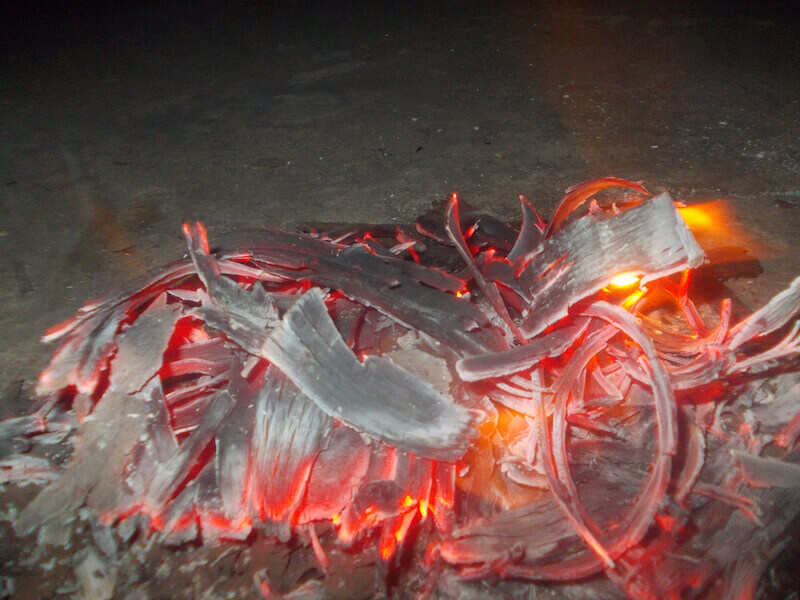 fan into flame showing burning piece of wood