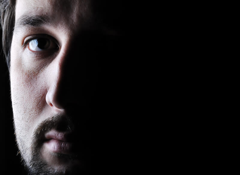 fear showing a man's face in the dark