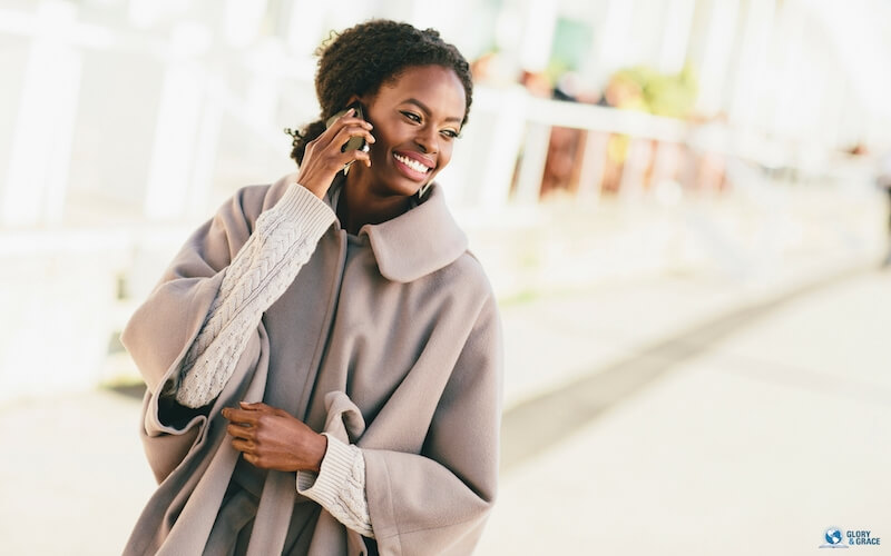 Grace be unto you showing a young and happy black woman on the phone