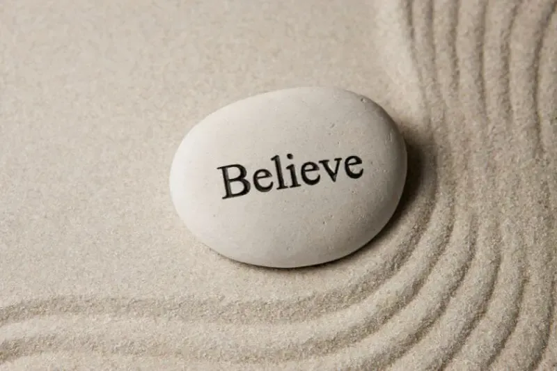 how our hearts believe god showing a pebble with the word believe