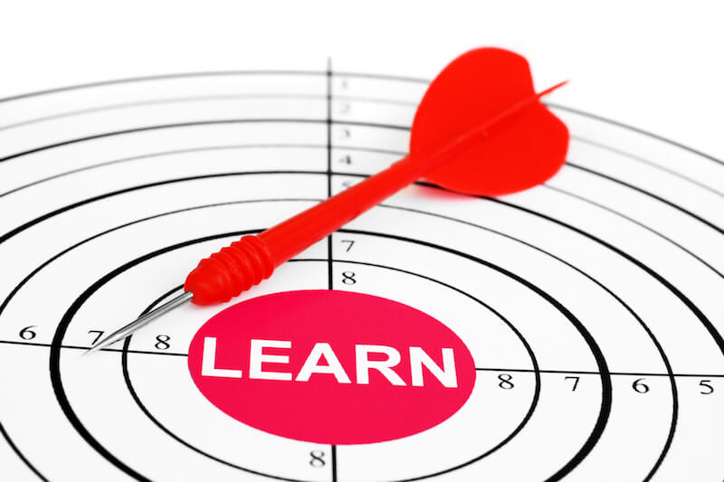Learning Christ showing a dart with a bull's eye target