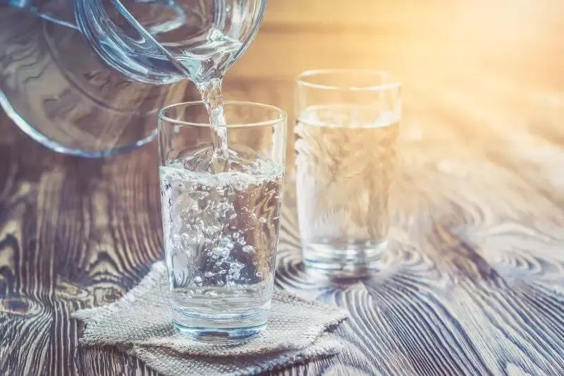 pour water on him that is thirsty showing a bottle filling a glass of water