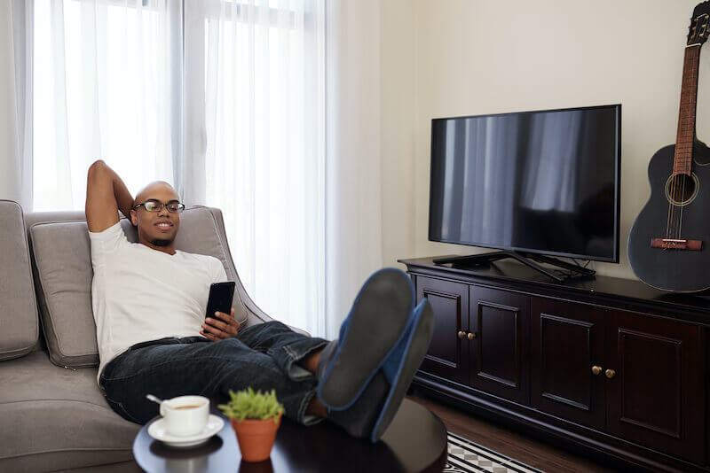 the sluggard says there is a lion in the streets showing a man sitting on his couch