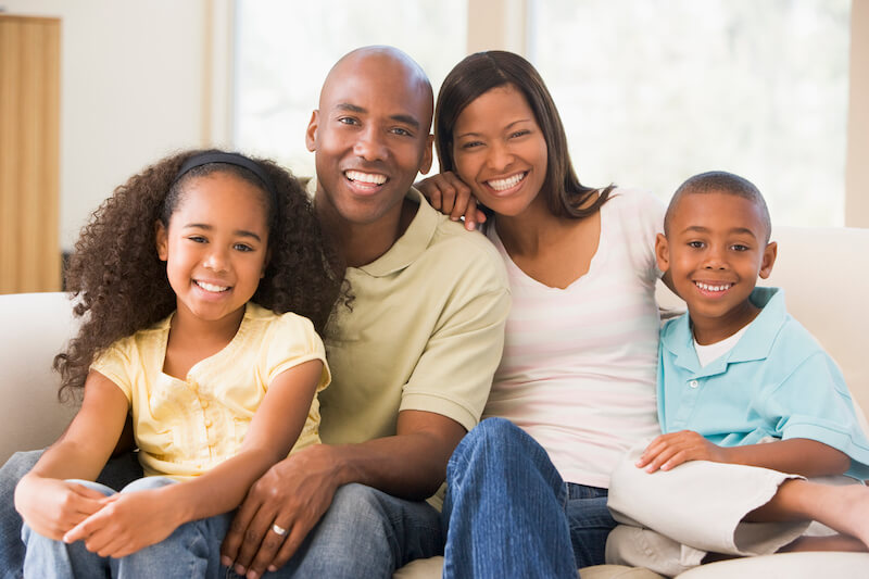 We shall not die but live showing a family in the living room