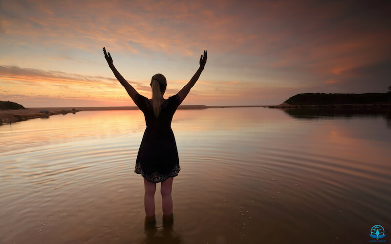 What is happening to worship? Image sowing a woman with lifted hands in water
