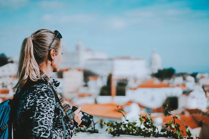 be not conformed to the world showing a woman looking at a city