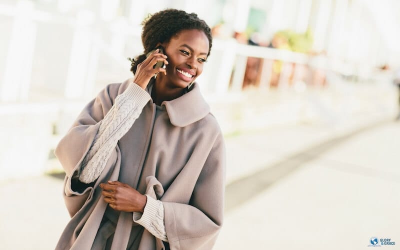 Grace be unto you showing a young and happy black woman on the phone