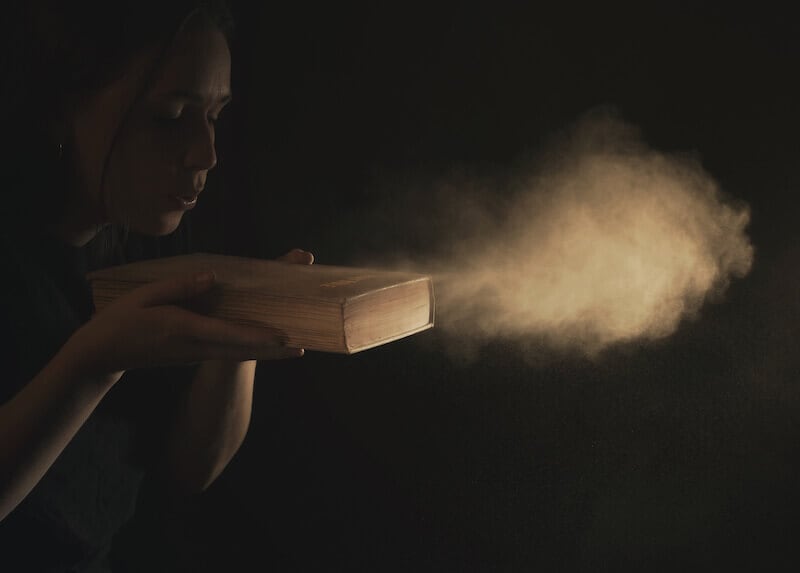 scripture is God breathed showing the Bible a woman blowing on the scripture