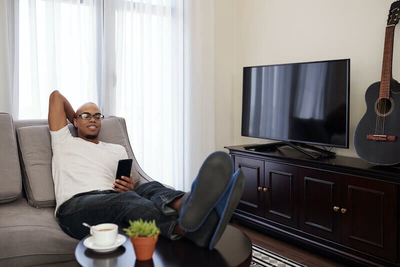 the sluggard says there is a lion in the streets showing a man sitting on his couch