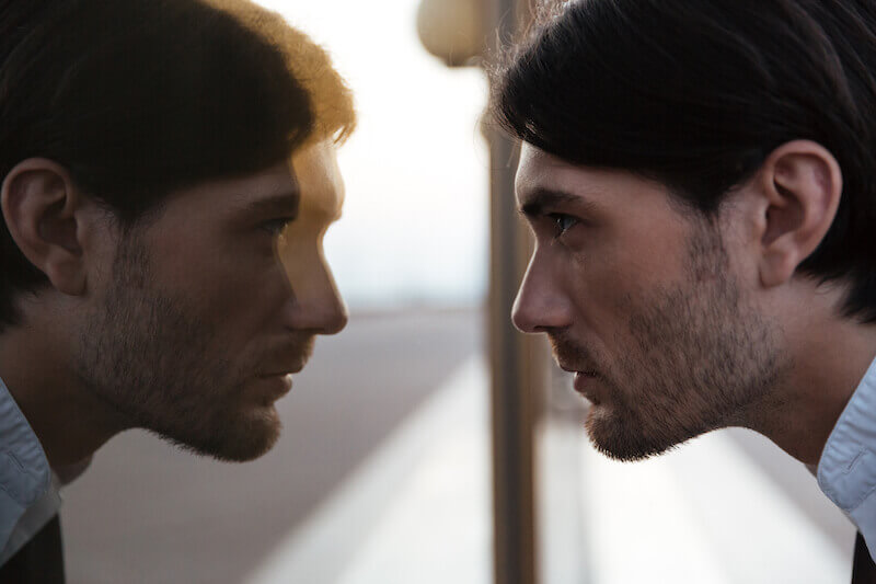 looking in a mirror for showing a man looking at his face in the mirror