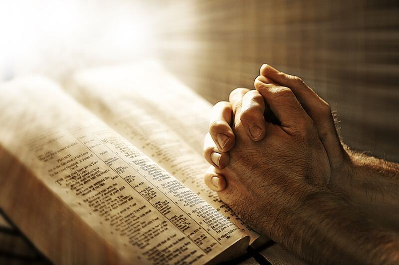 devotional life showing a man praying with his bible