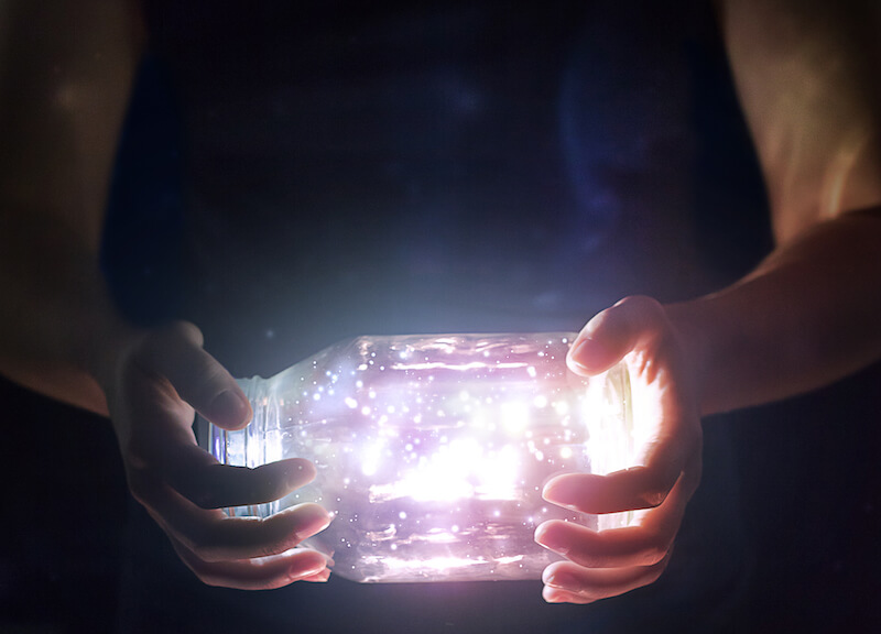 light shines in the darkness showing a woman holding a bottle of light