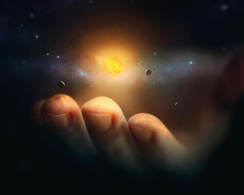 What holds the universe? picture of a hand holding the galaxies