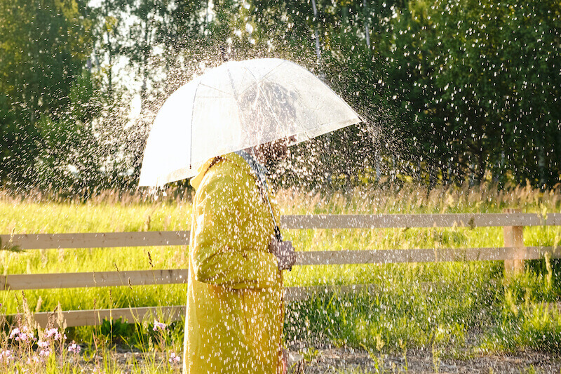 a woman in yellow rain coat under the rain
