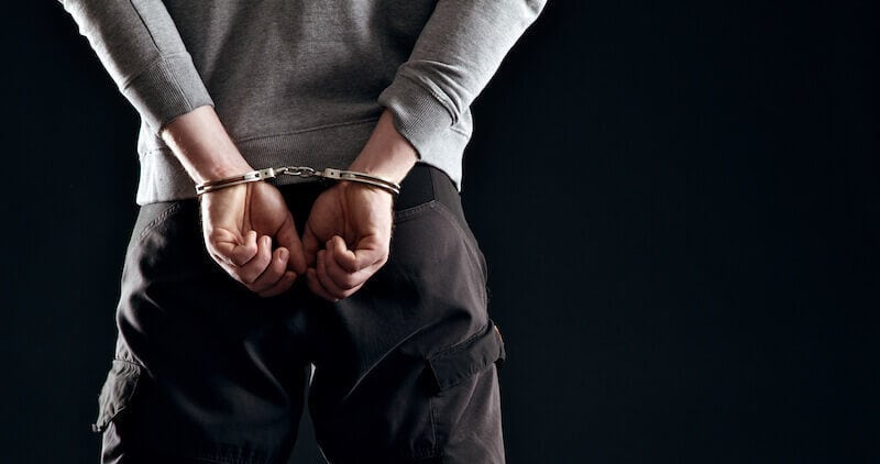 Forgiveness showing a man in handcuffs behind him