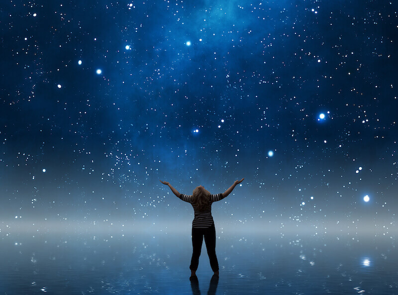 a woman watching the sky with hand lifted up