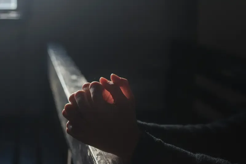 pray without ceasing showing hands together in the dark
