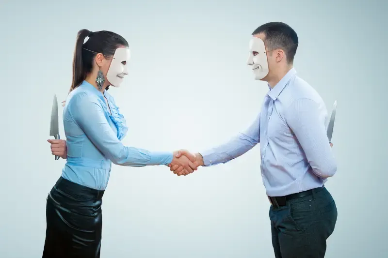 Hypocrisy showing a man greeting a woman and both with knives hidden